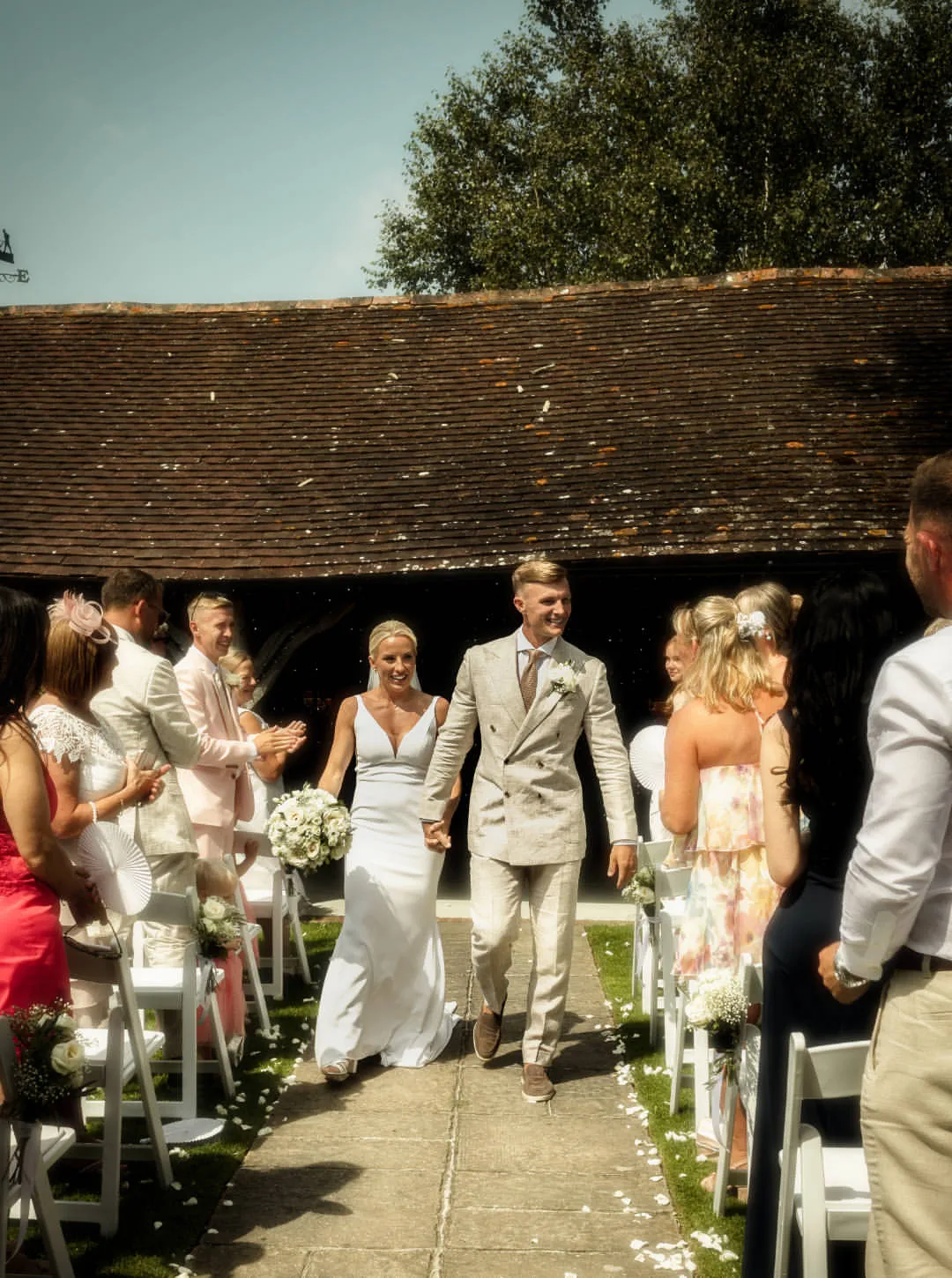 An exceptionally happy outdoor summer wedding ceremony exit at Winters Barns ...
